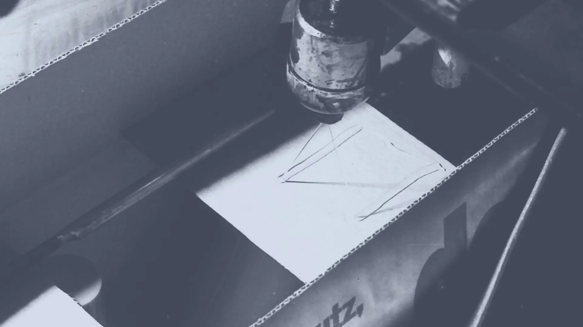 Η θερμοκολλητική κόλλα Technomelt εφαρμόζεται σε ένα χάρτινο κουτί με εκτοξευτήρα για να το σφραγίσει.