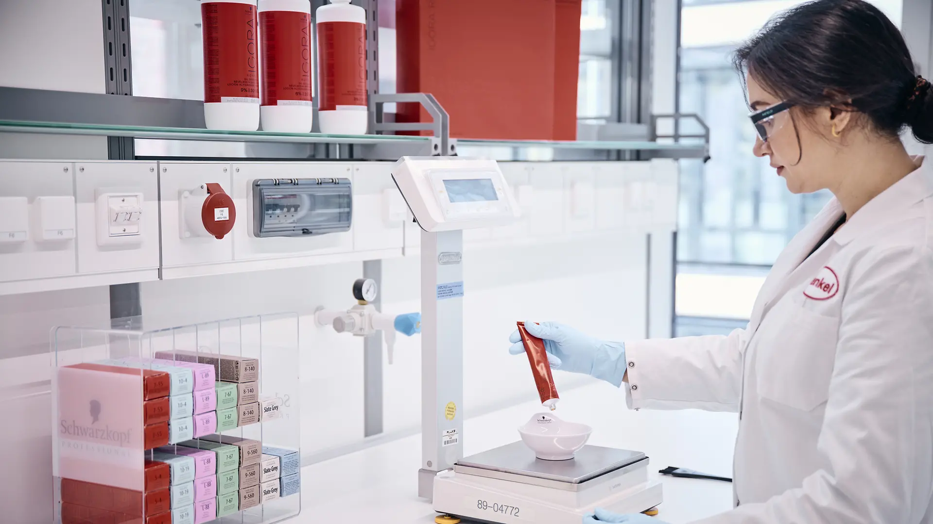 Εργαζόμενος στο εργαστήριο ζυγίζει δοκιμαστικά προϊόντα.