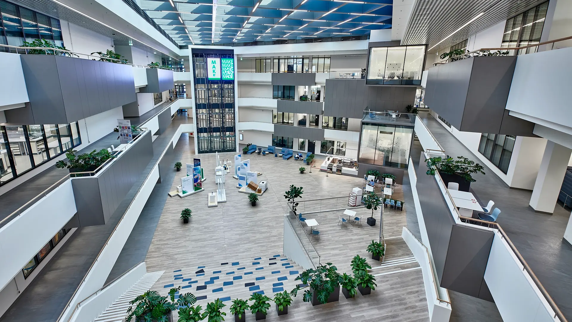 Εσωτερική όψη του Inspiration Center Düsseldorf με τη μεγάλη εσωτερική αυλή στο κέντρο. Η εικόνα δείχνει επίσης τα υπερσύγχρονα εργαστήρια με γυάλινες προσόψεις, κατανεμημένα σε συνολικά τέσσερις ορόφους.